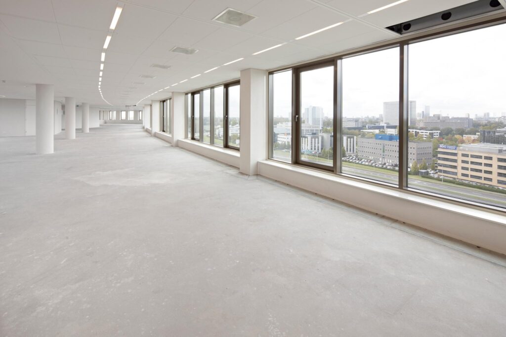 Lichte, lege kantoorruimte aan de Fascinatio Boulevard met grote ramen en uitzicht op een modern zakendistrict.